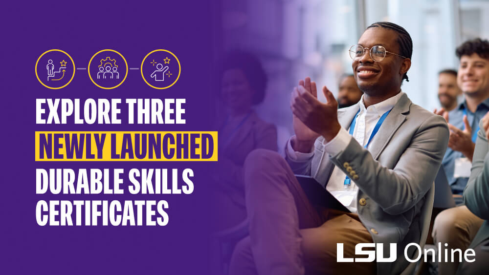 A smiling man in suit applauding at an event.